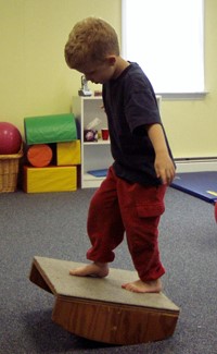 boy standing on rocker board